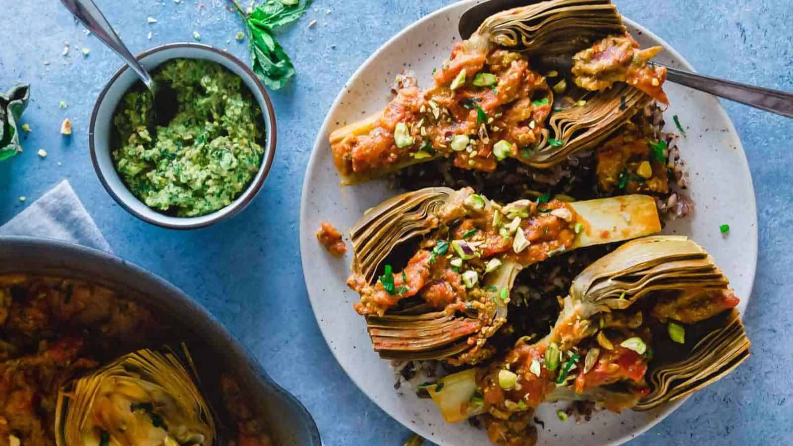 A plate of Tomato Braised Artichokes with Pistachio Pesto.