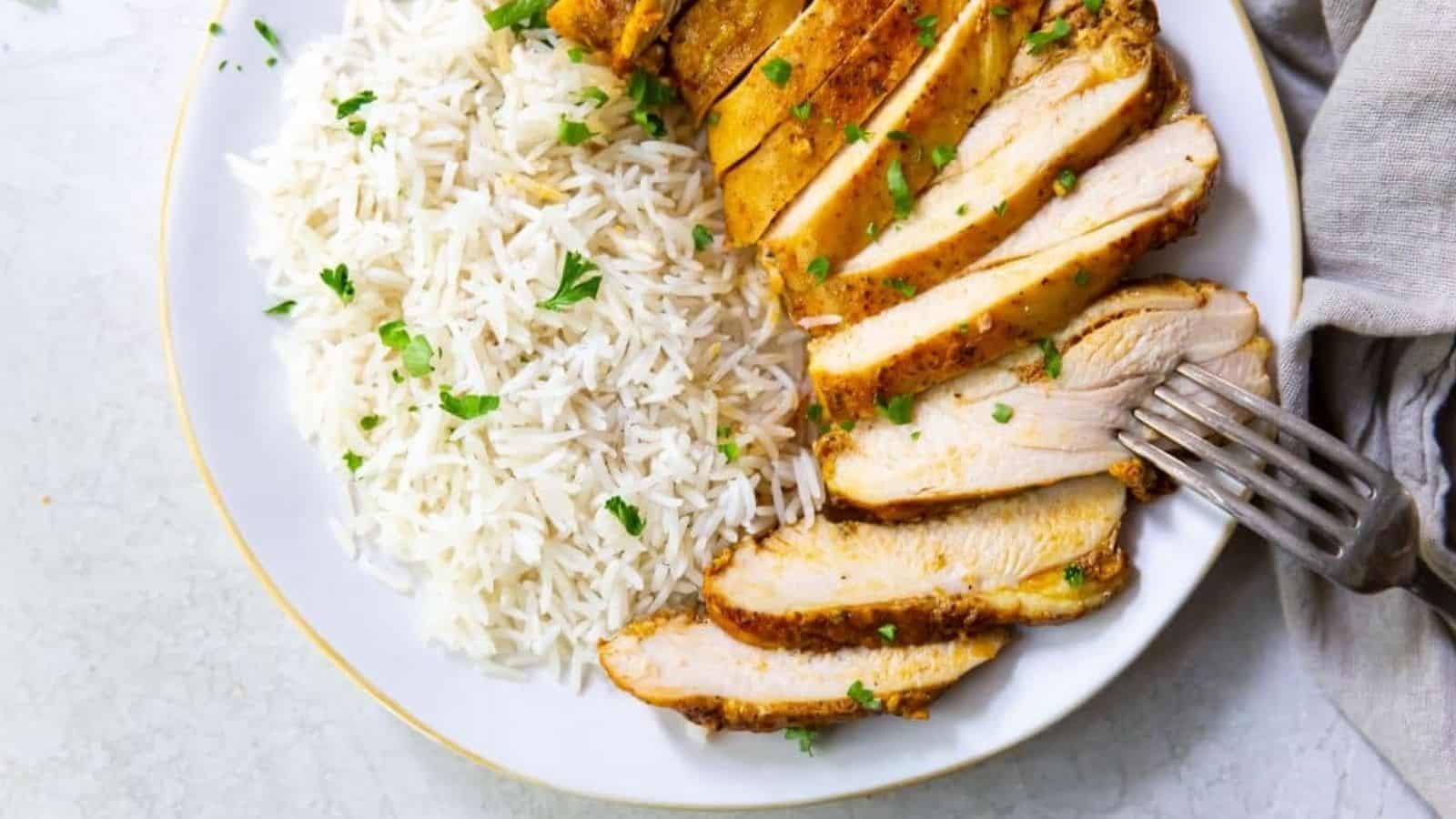 Trader Joe's Shawarma Chicken Thighs in the Air Fryer on a white plate with white rice, a fork, and parsley.