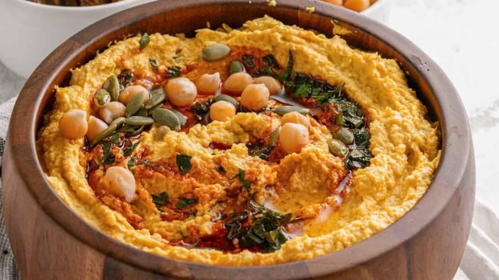 Vegan roasted pumpkin hummus in a wooden bowl.