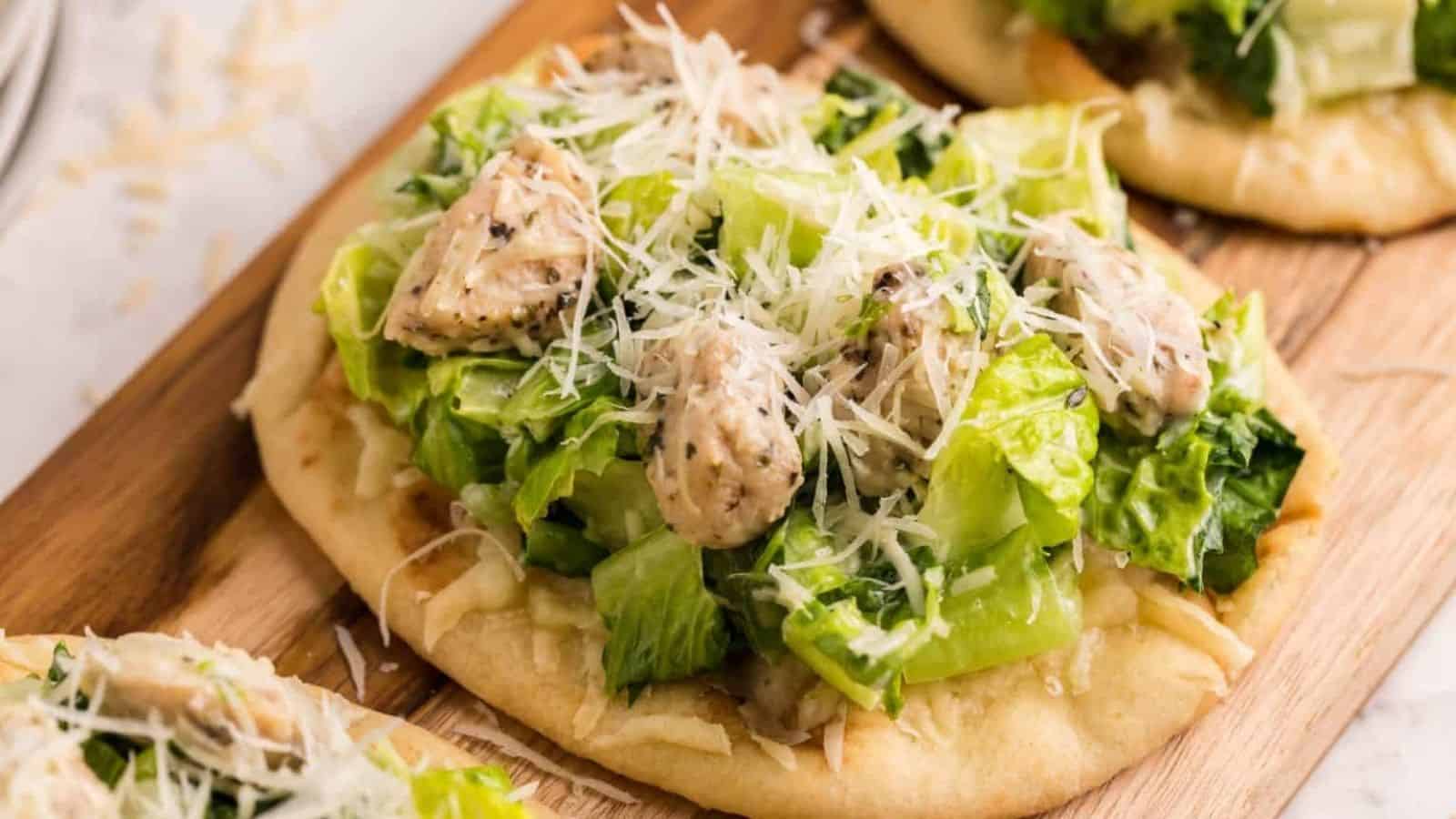 Small flatbread toped with salad and chicken.