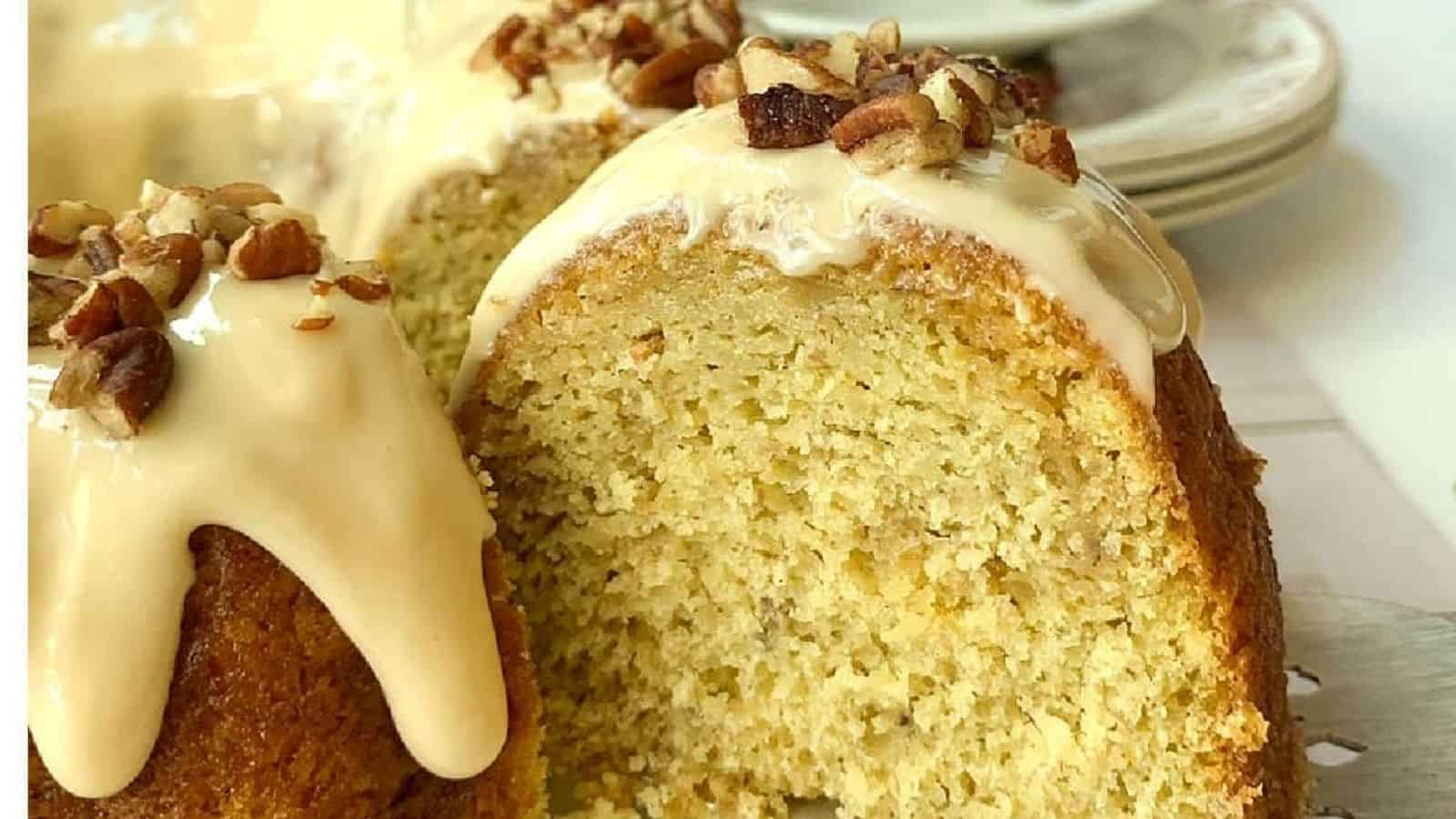 Iced banana cake with pecans on top.