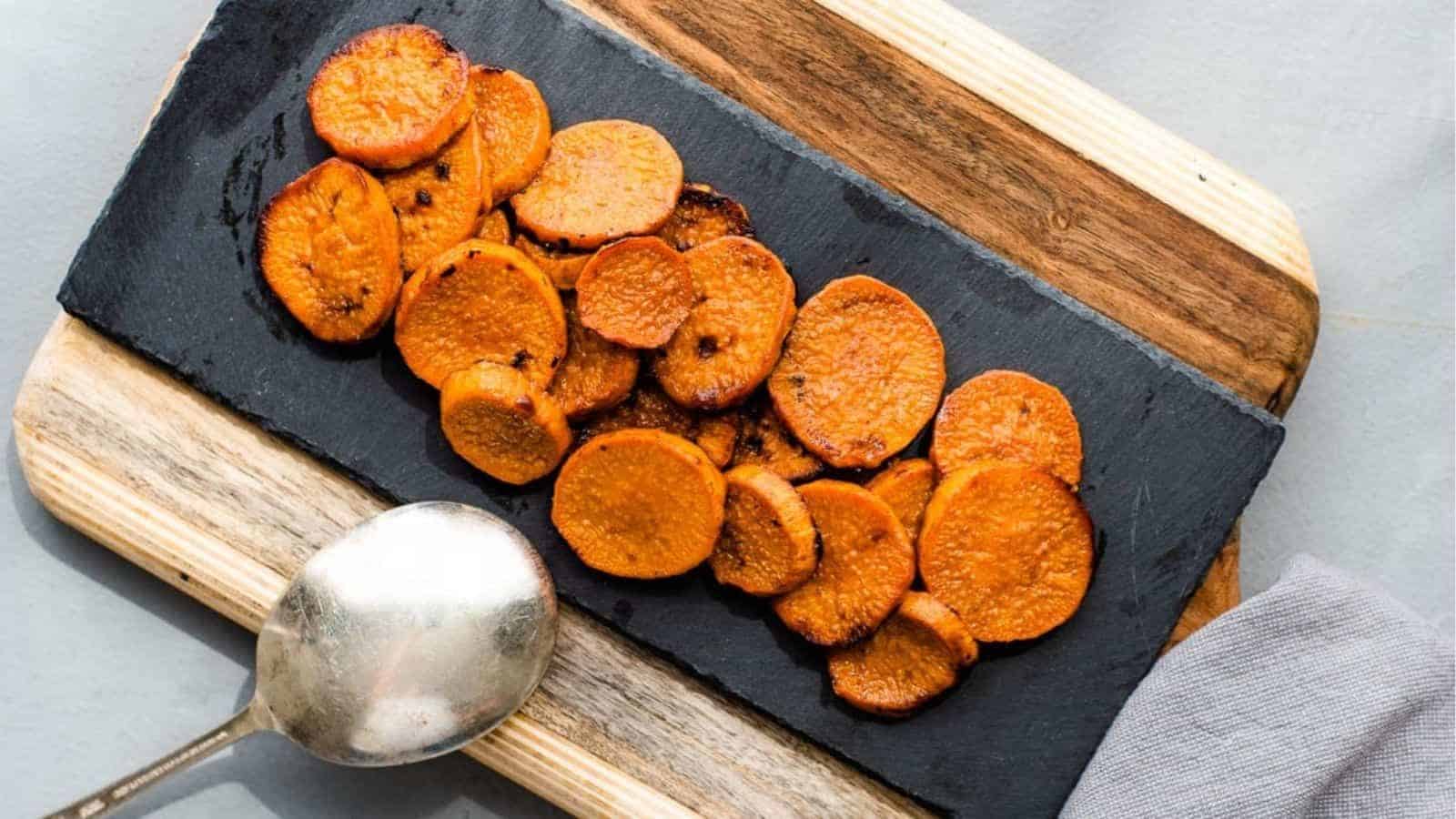 Baked sweet potato slices on a cutting board with a spoon.