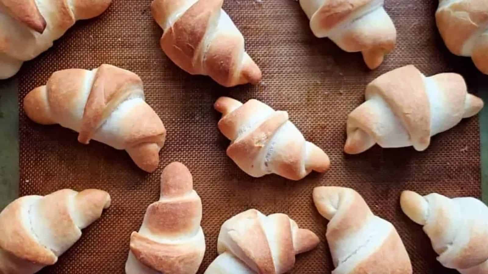 Image shows an overhead view of homemade Crescent Rolls on a baking sheet.