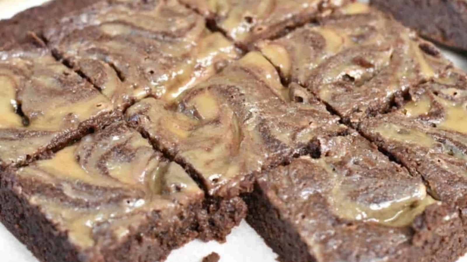 A plate of chocolate brownies with caramel swirls.