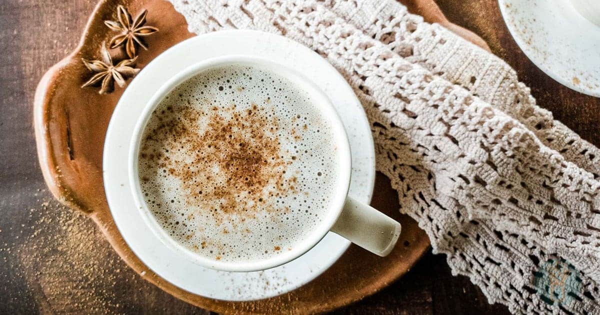 Chocolate Chai Latte in white teacup on clay dish with lace napkin.