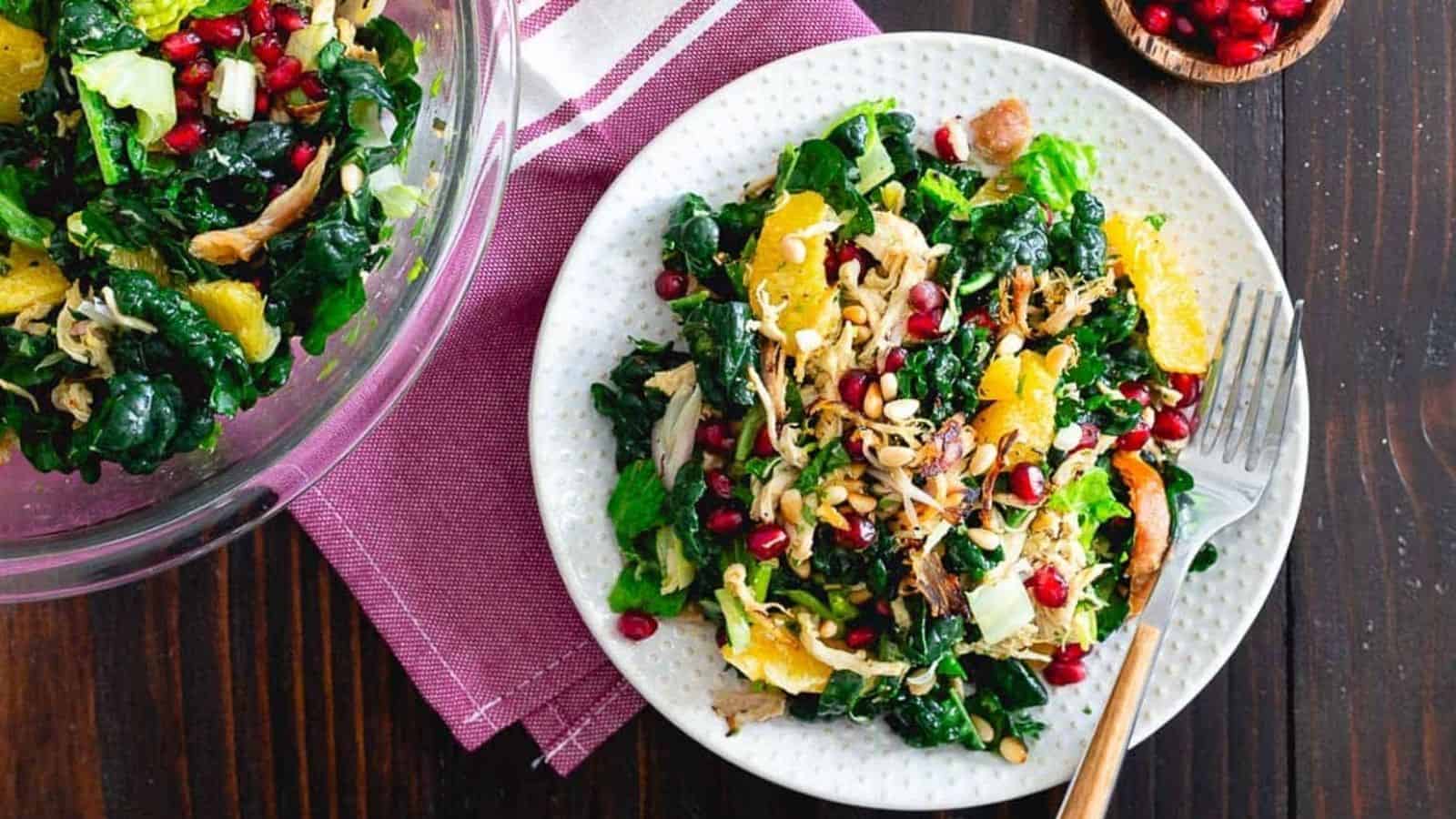 Chopped crispy chicken citrus salad on a white plate with purple kitchen towel.