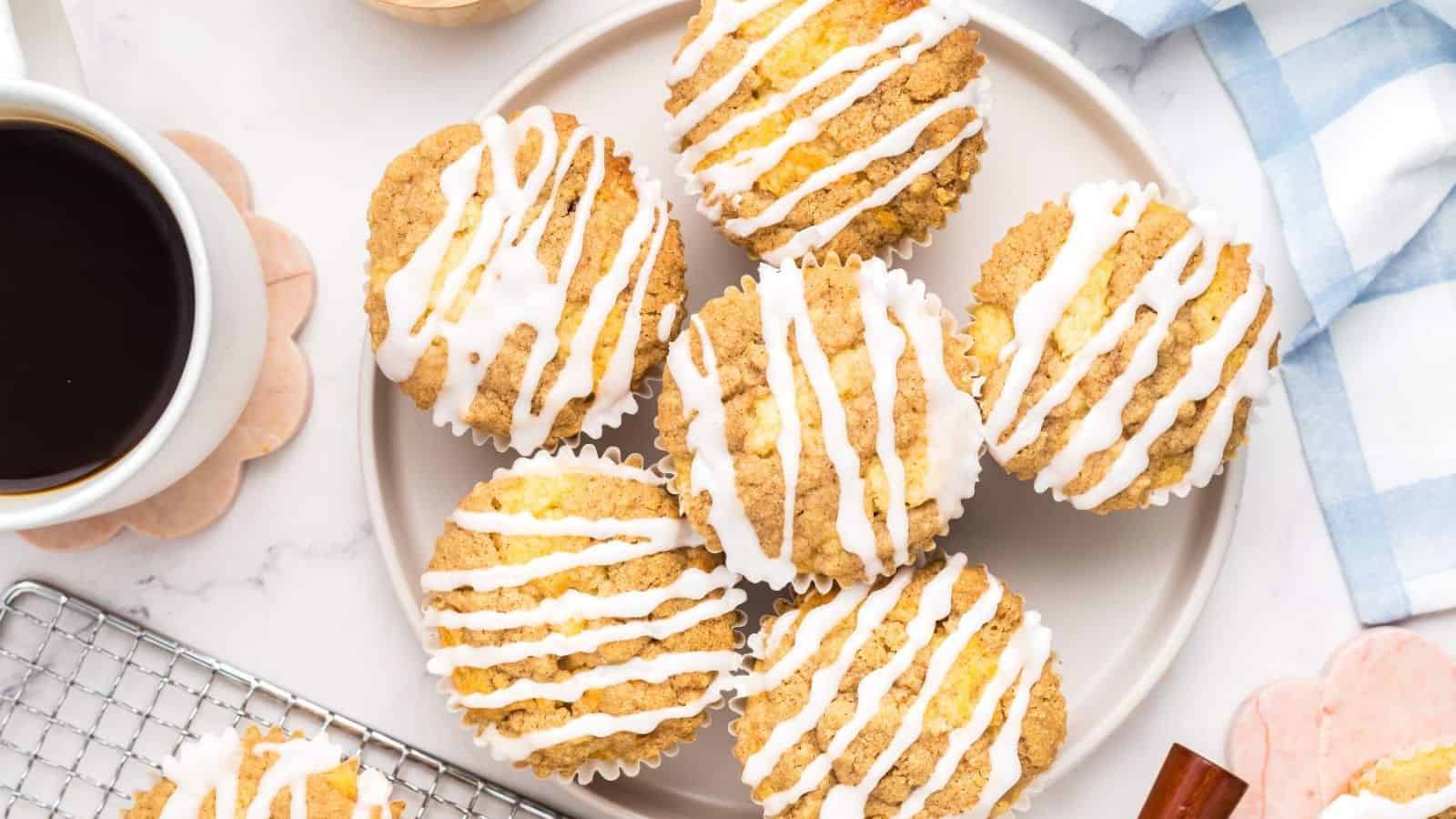 Coffee Cake Muffins on a plate with a cup of coffee on the side.