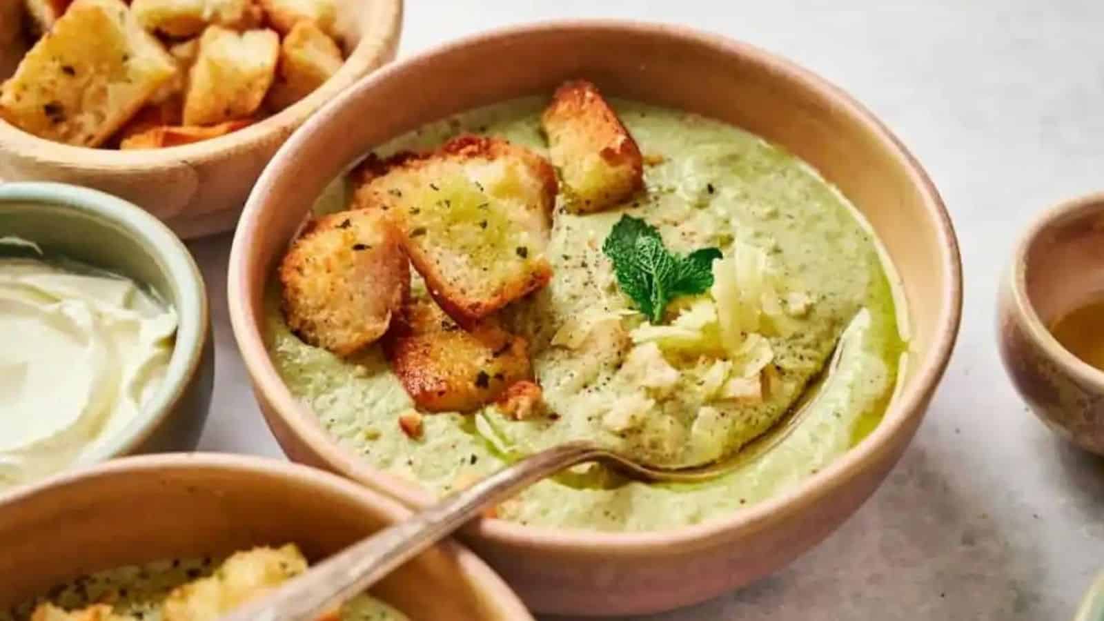 Creamy cheesy broccoli soup with a spoon in a bowl.