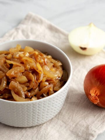 Organic caramelized onions in a bowl on a cloth.