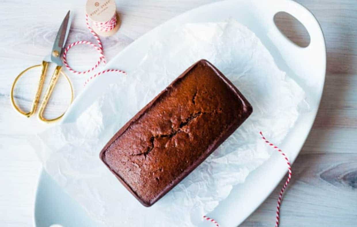 A loaf of gingerbread on a white platter.