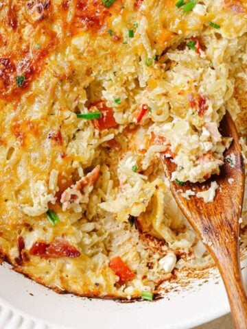 Hash brown breakfast casserole with a wooden spoon in it.