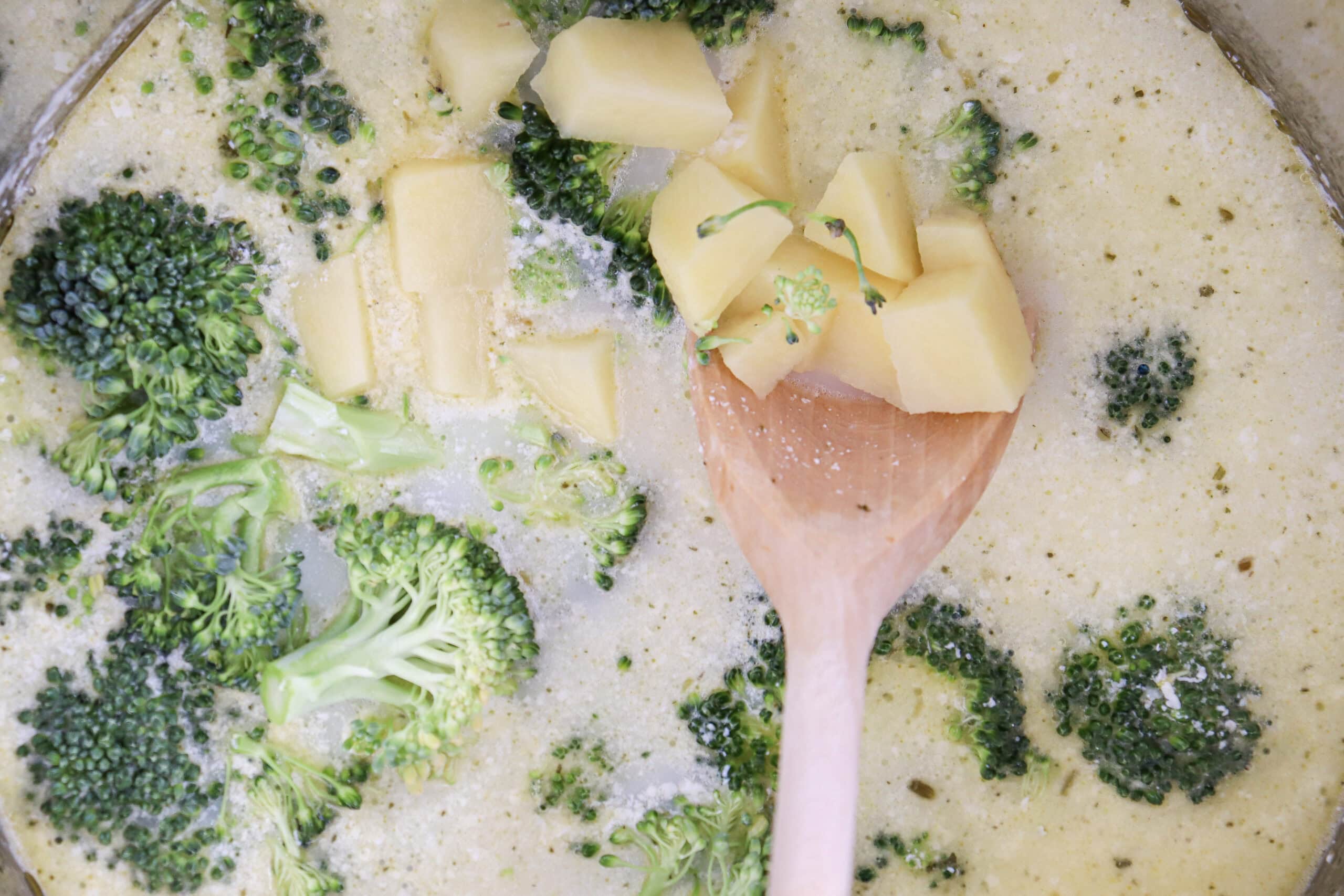 Close-up image of cheddar cheese being added in the soup.