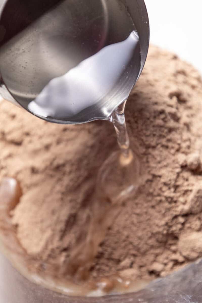 Water being poured into the peanut butter brownie ingredients.