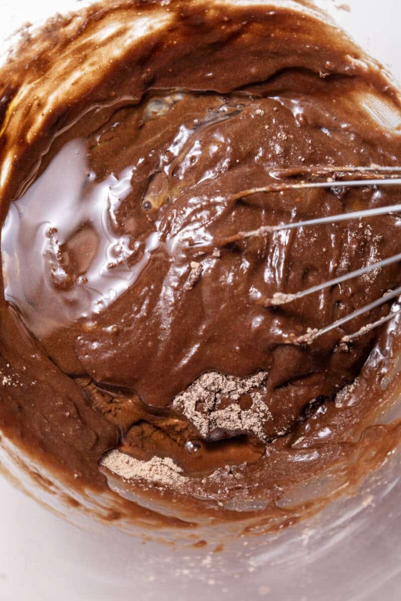 Overhead image of a whisk dipped in peanut butter brownie batter.