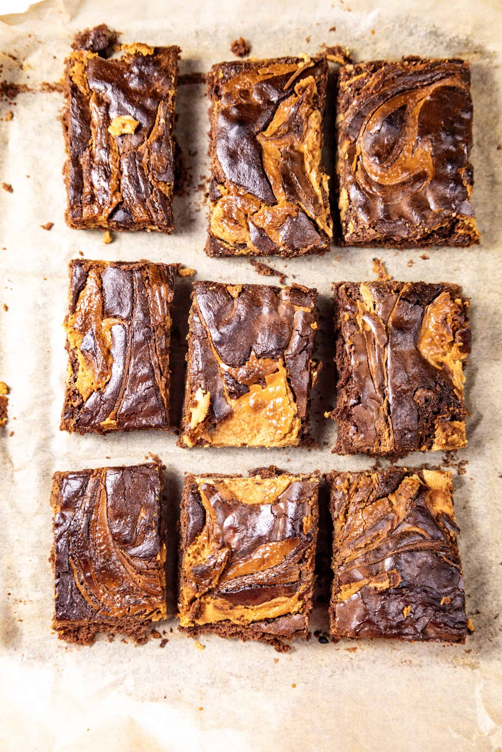 An overhead image of a batch of peanut butter brownies on a brown surface.