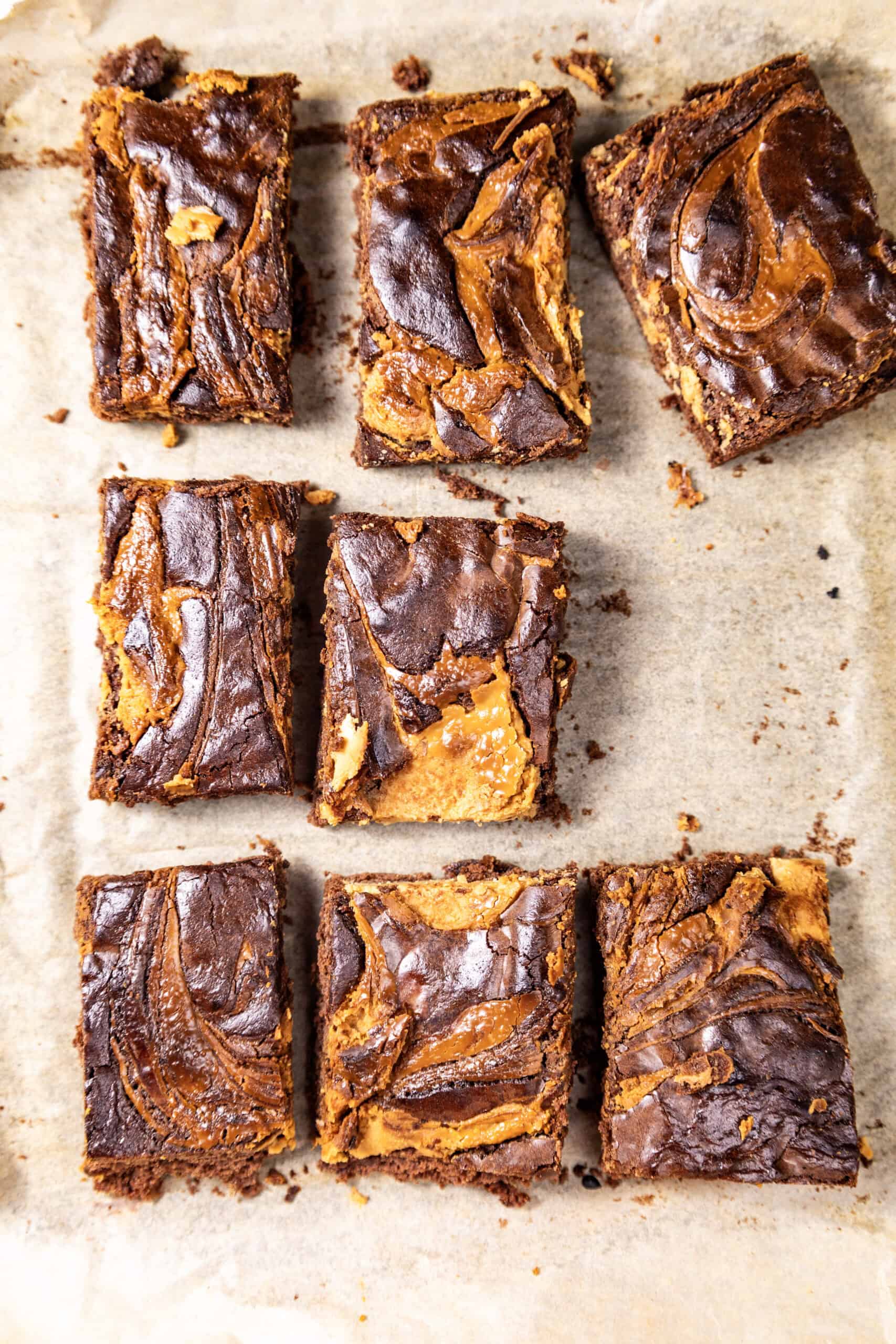 An overhead image of a batch of peanut butter brownies on a brown surface.