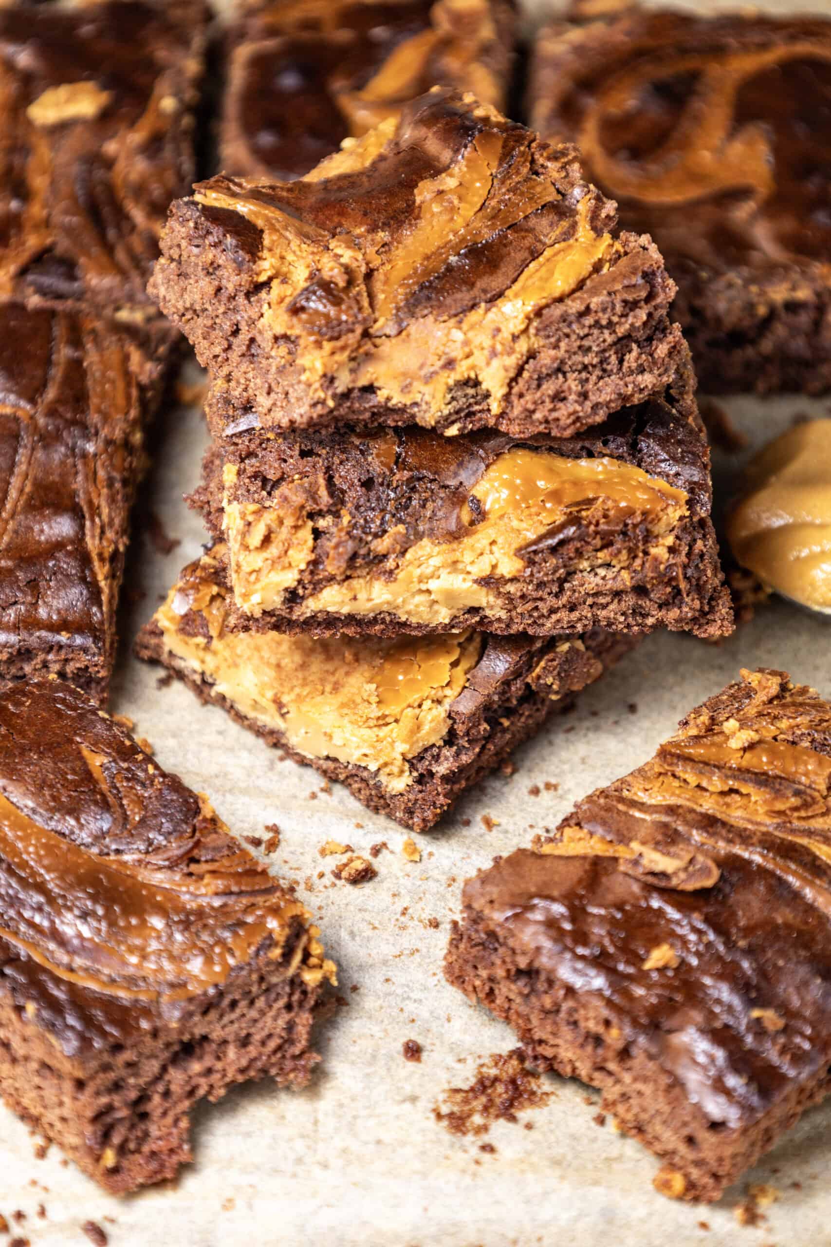 Close-up image of a batch of peanut butter brownies with a stack of three in the middle.