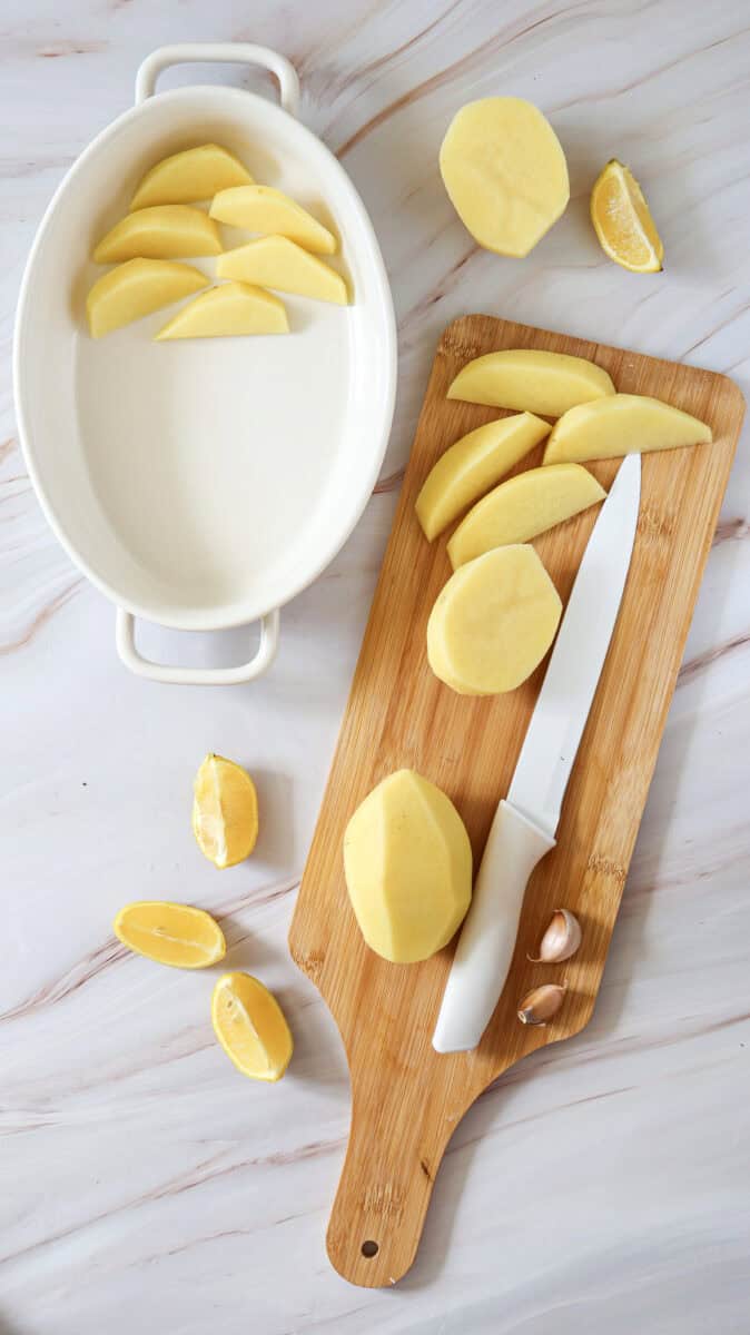 An overhead image of sliced lemon and potatoes.