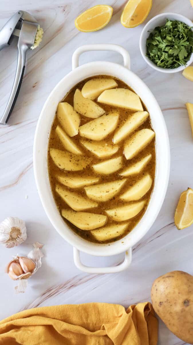 An overhead image of potato wedges with the liquid mixture in the dish.