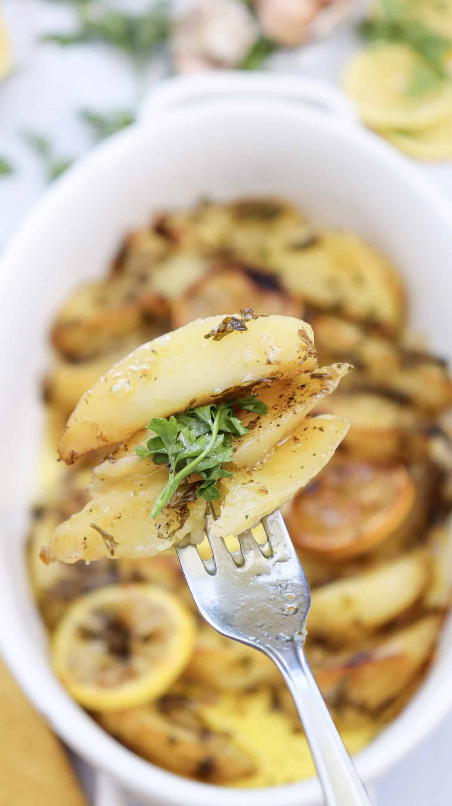 Close-up image of a fork with lemon Greek potatoes.