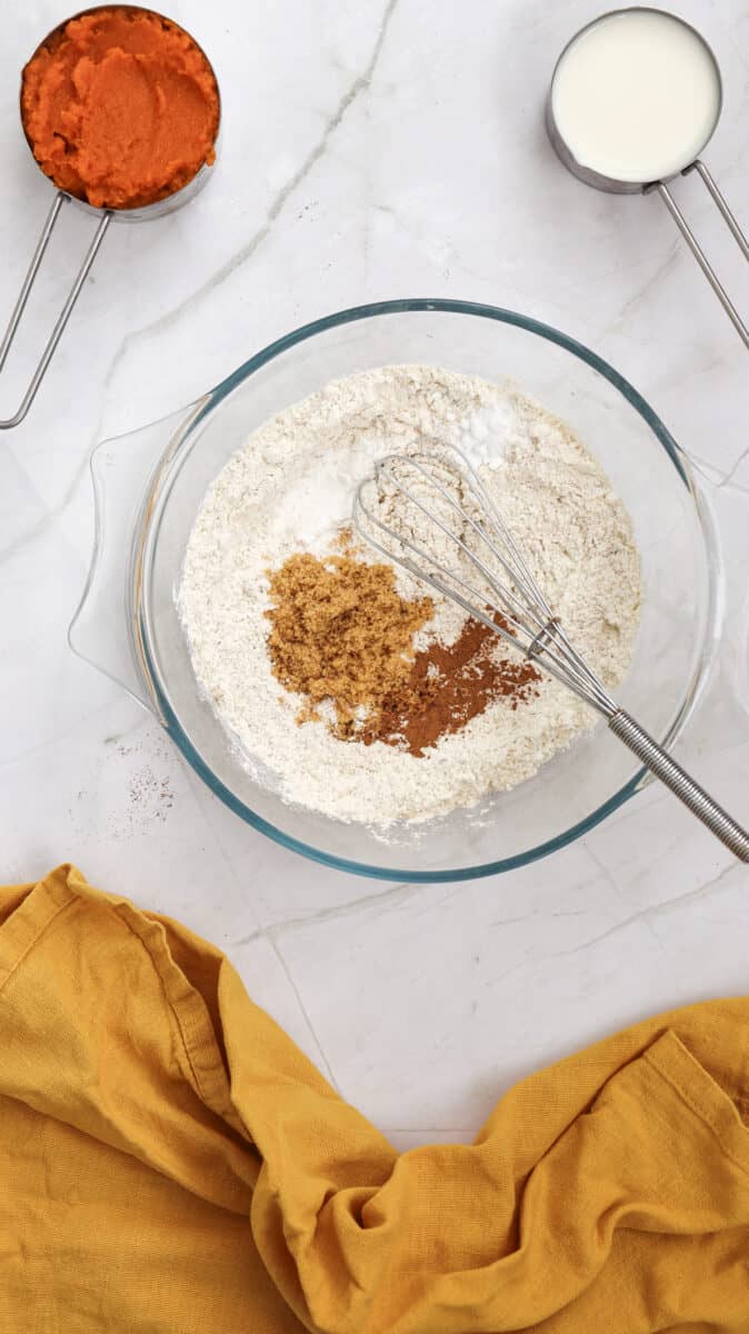 Overhead image of dry ingredients in a mixing bowl with a whisk.