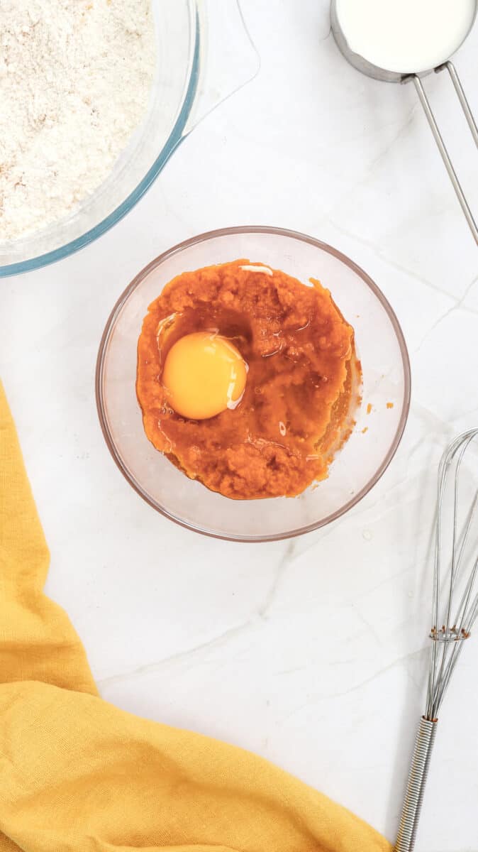 Overhead image of egg and pumpkin puree in a bowl.