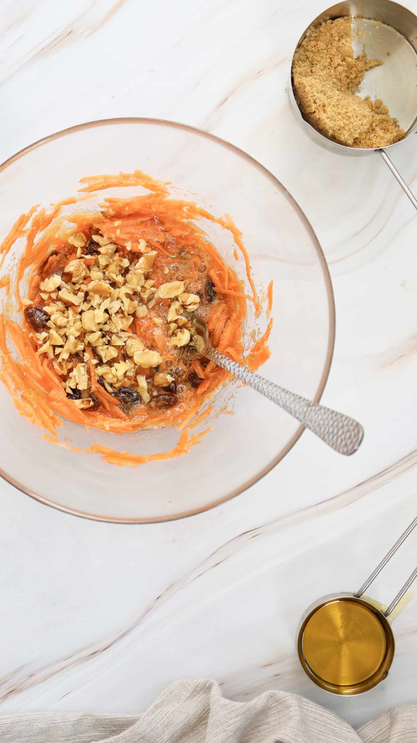 An overhead image of carrot cake muffins ingredients in a mixing bowl.