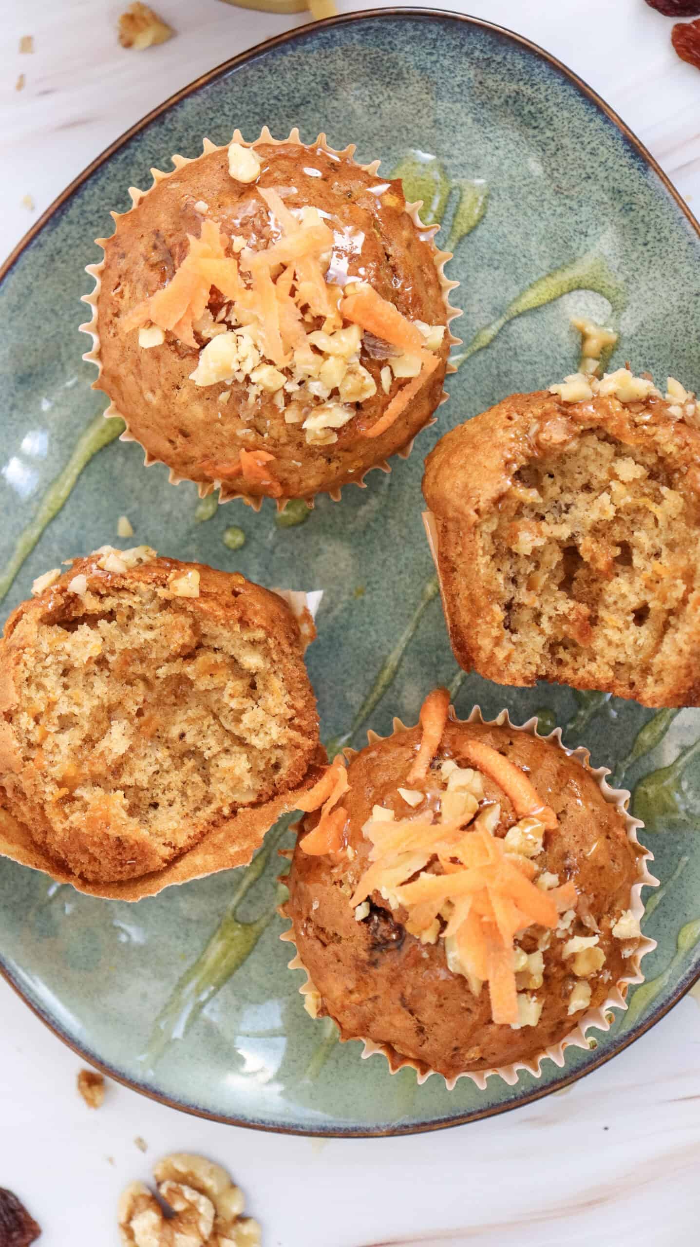 Overhead image of four carrot cake muffins, two of them are bitten.