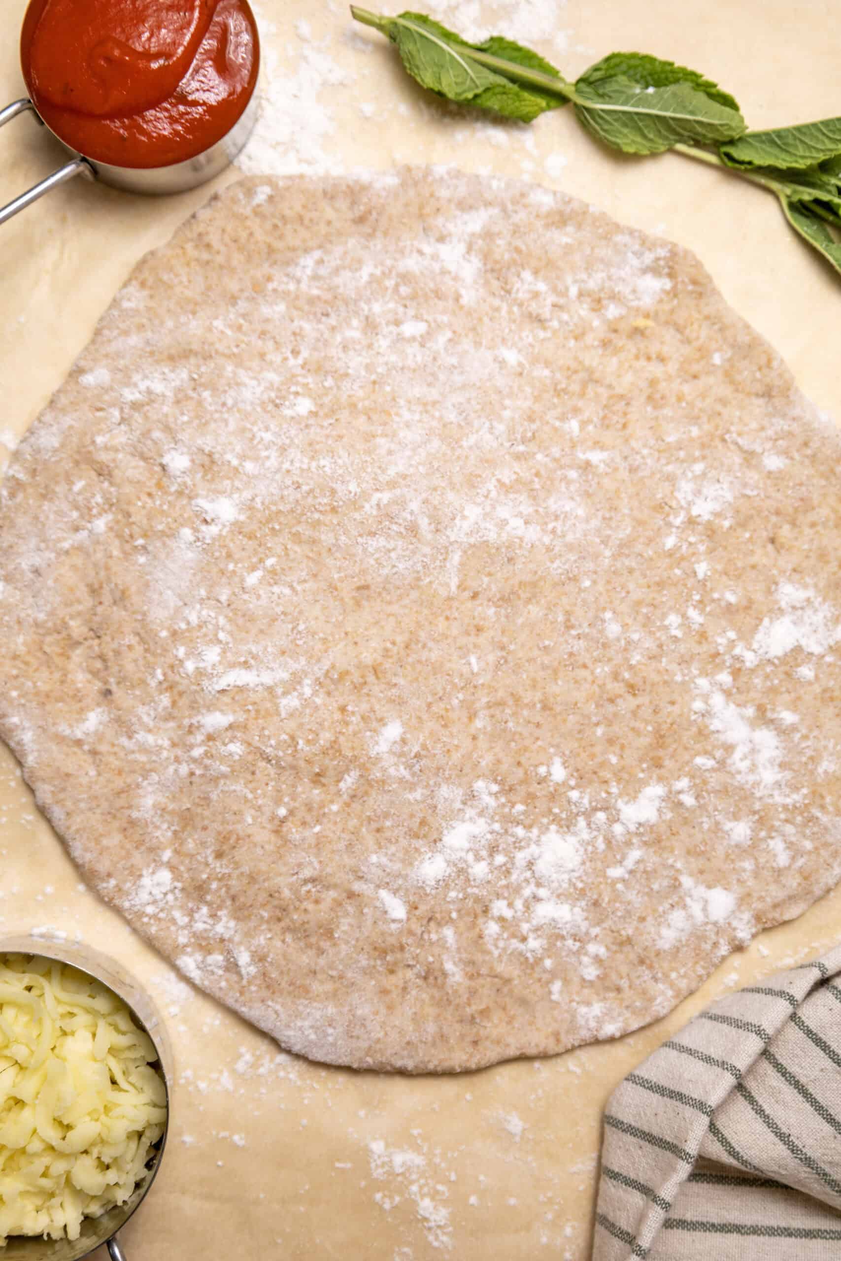 Overhead image of flattened homemade Margherita pizza dough.