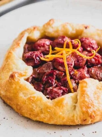 Close-up image of mini tart galette with a fork on a plate.