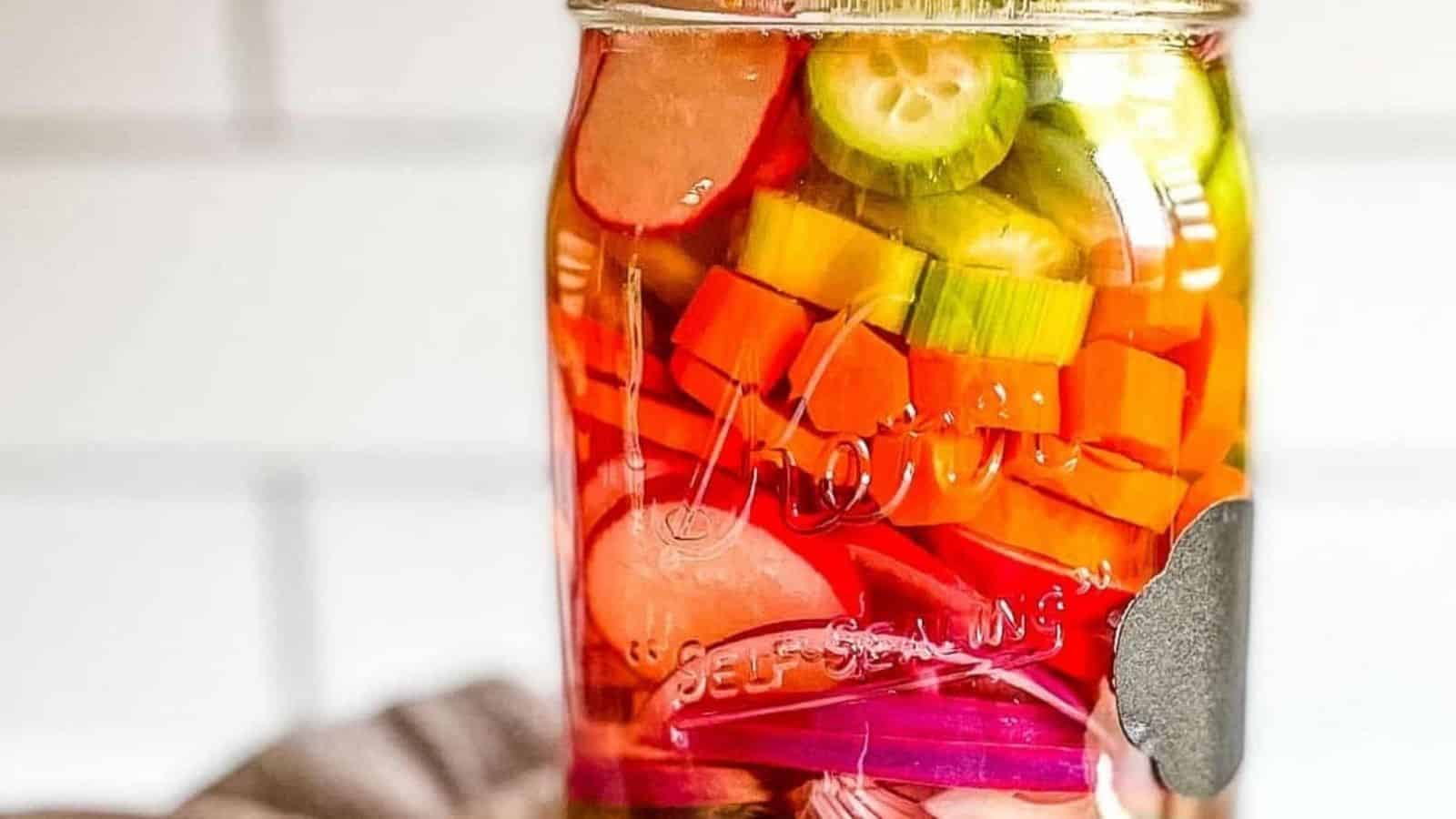 Side view of mixed pickles in a glass jar.