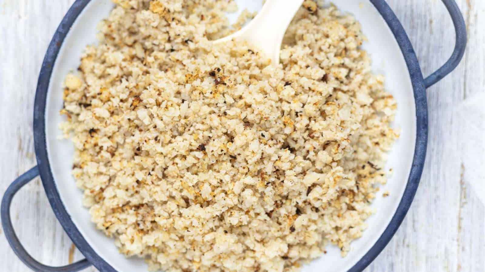 Baked Riced Cauliflower in a bowl with a spoon.