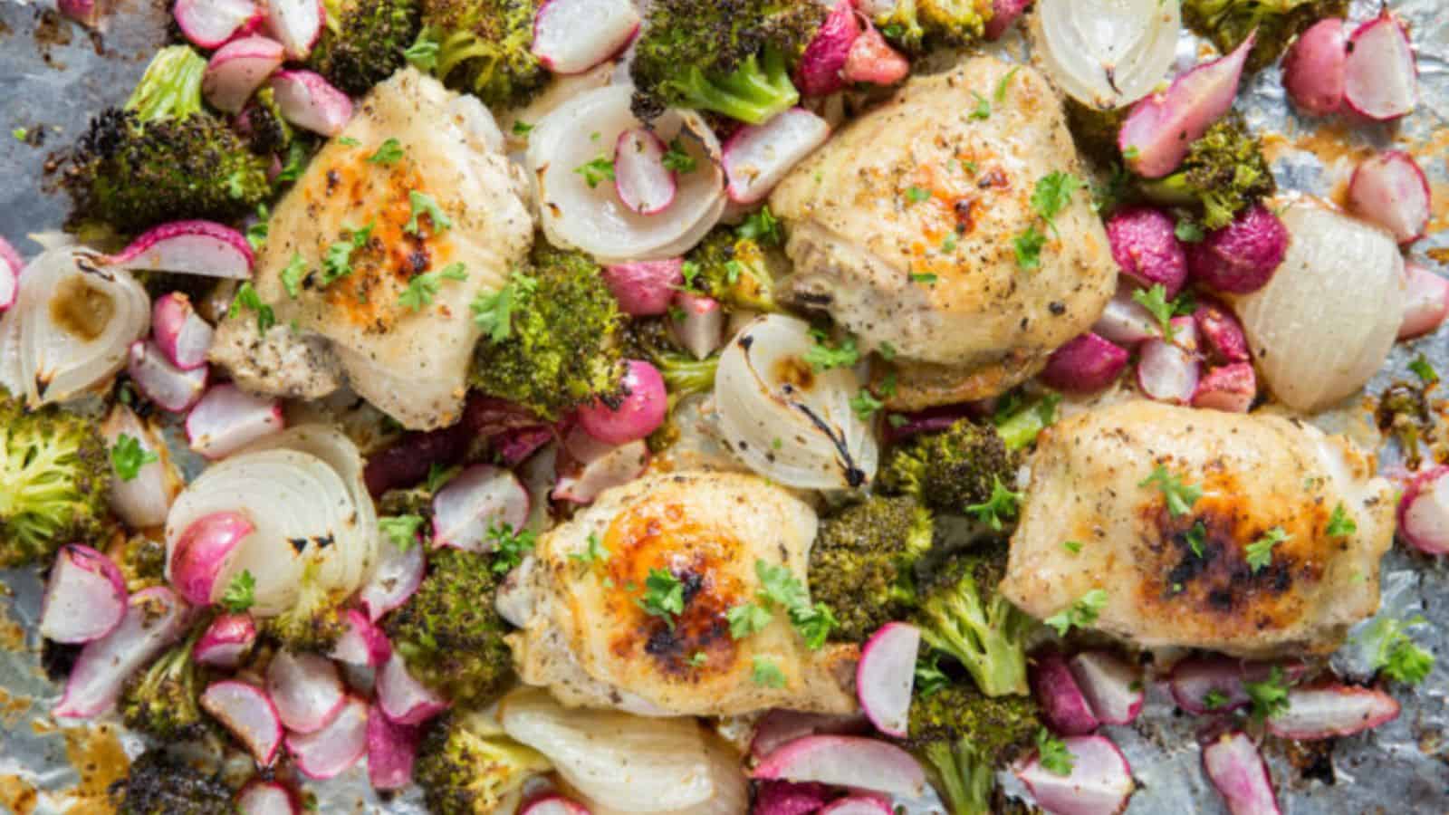 Sheet Pan Chicken and Vegetables on a sheet pan with foil, broccoli, onions, radishes, and parsley.