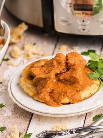 A plate and bowl of Slow Cooker Dairy Free Butter Chicken with Cauliflower Rice.