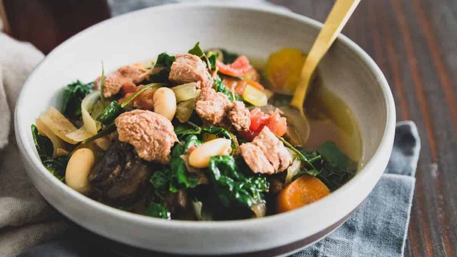 A bowl of slow cooker lamb stew with a spooon.