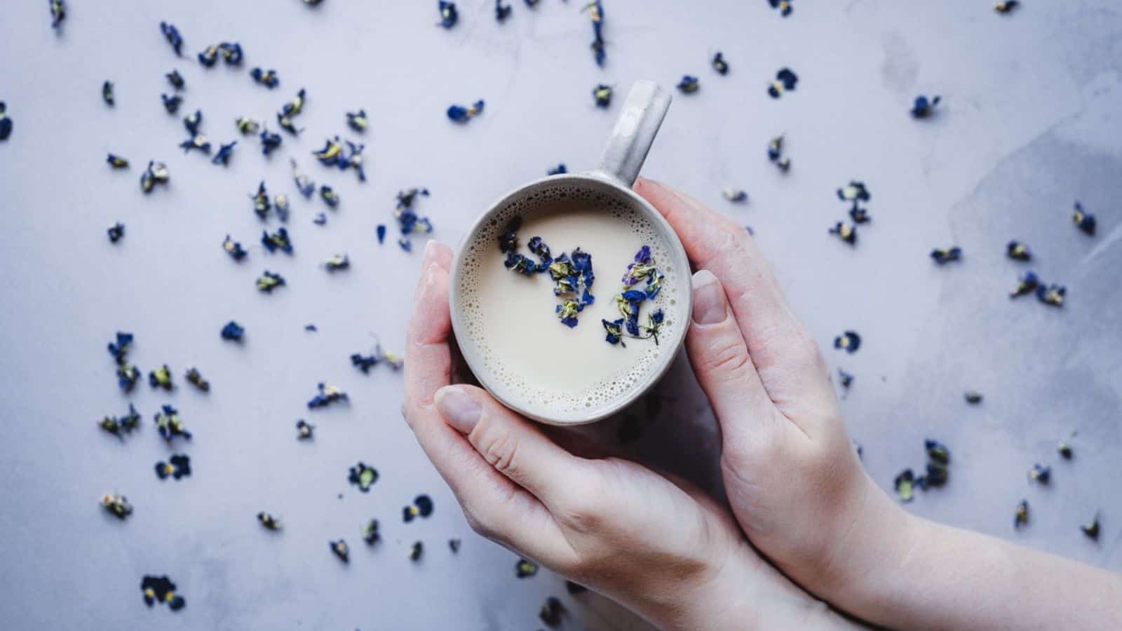 Someone holding a mug of Sweet Violet Moon Milk.