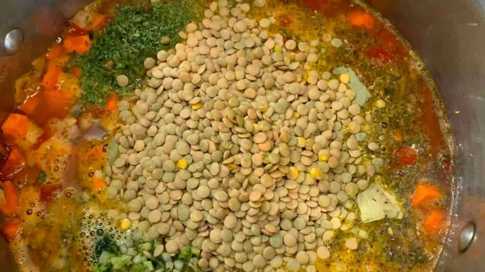 A pot of veggie lentil soup, filled with vegetables and lentils.