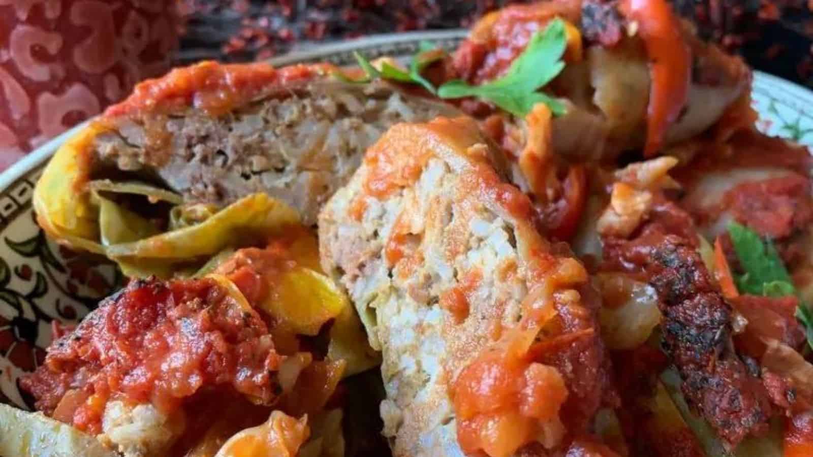 Stuffed cabbage rolls in a serving dish with sauce.