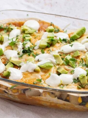 An image of vegetarian enchilada casserole in a clear baking dish.