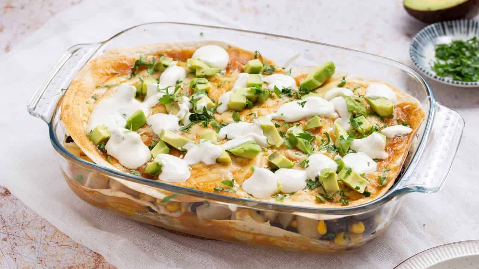 An image of vegetarian enchilada casserole in a clear baking dish.