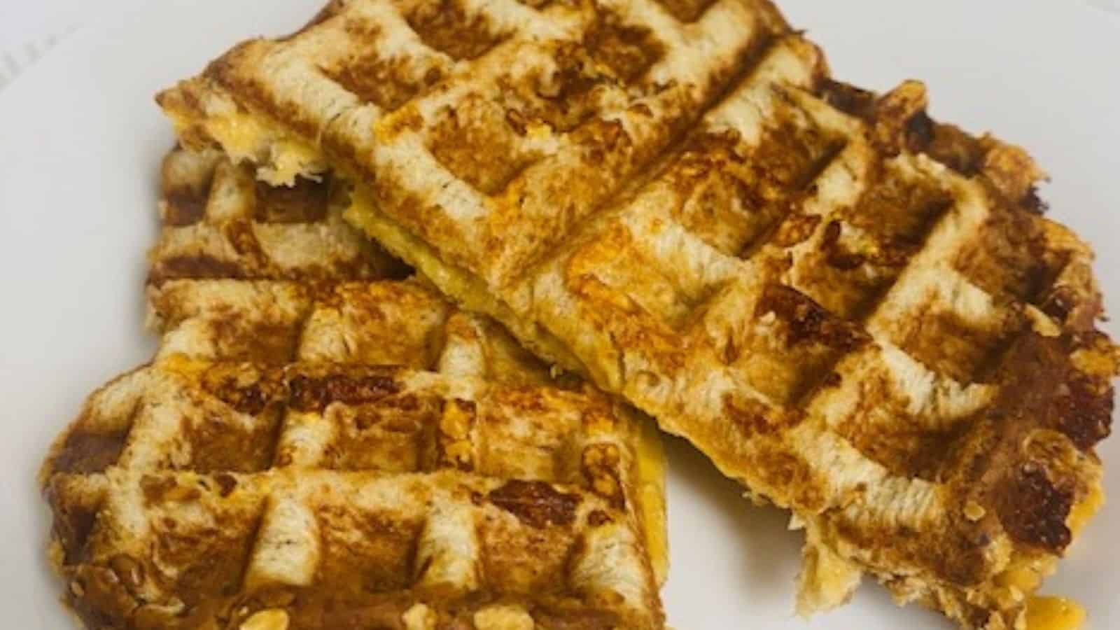 Waffle grilled cheese on a white plate with flowers.