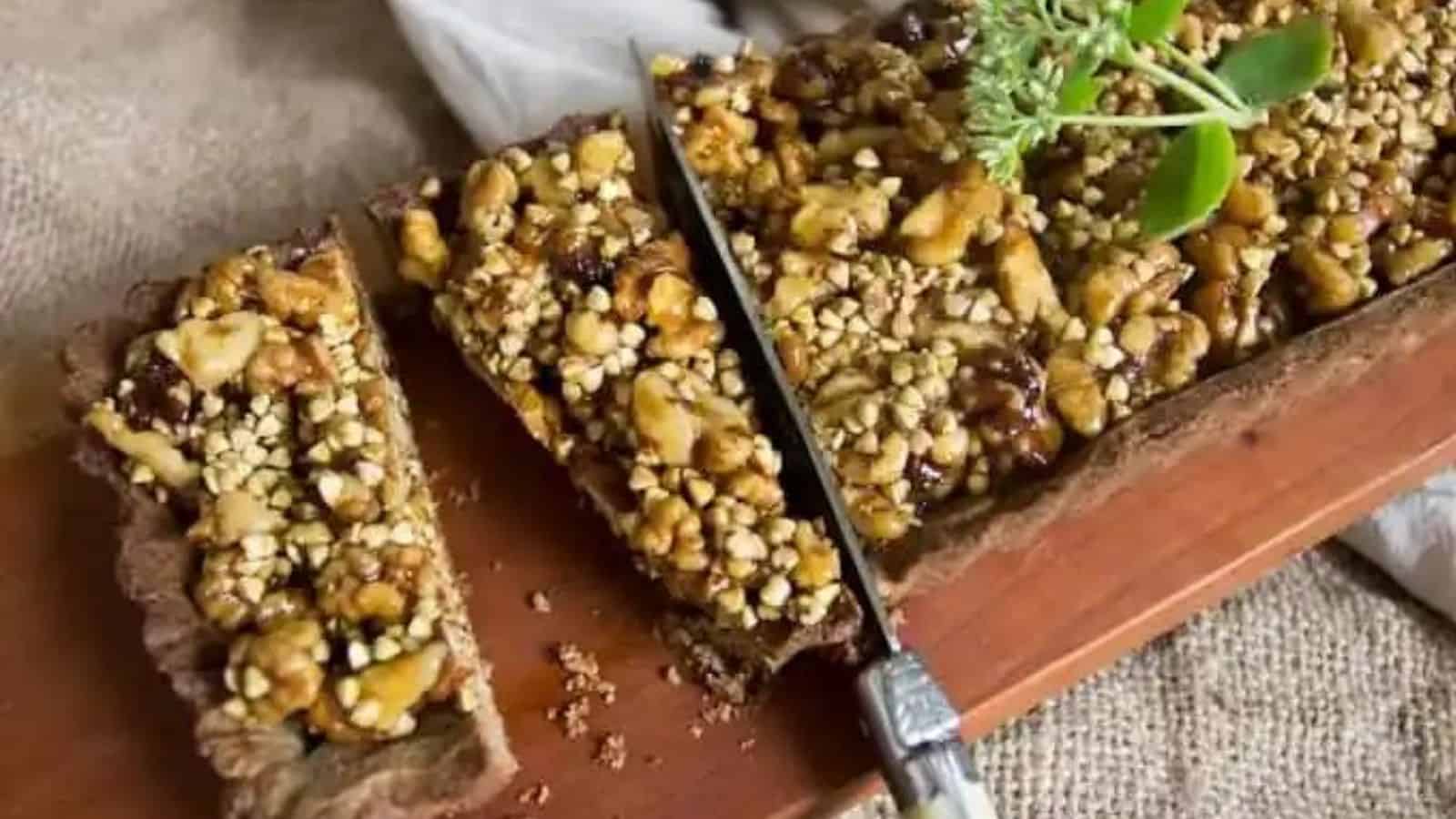 Close-up image of wlanut and buckwheat caramel tart being sliced.