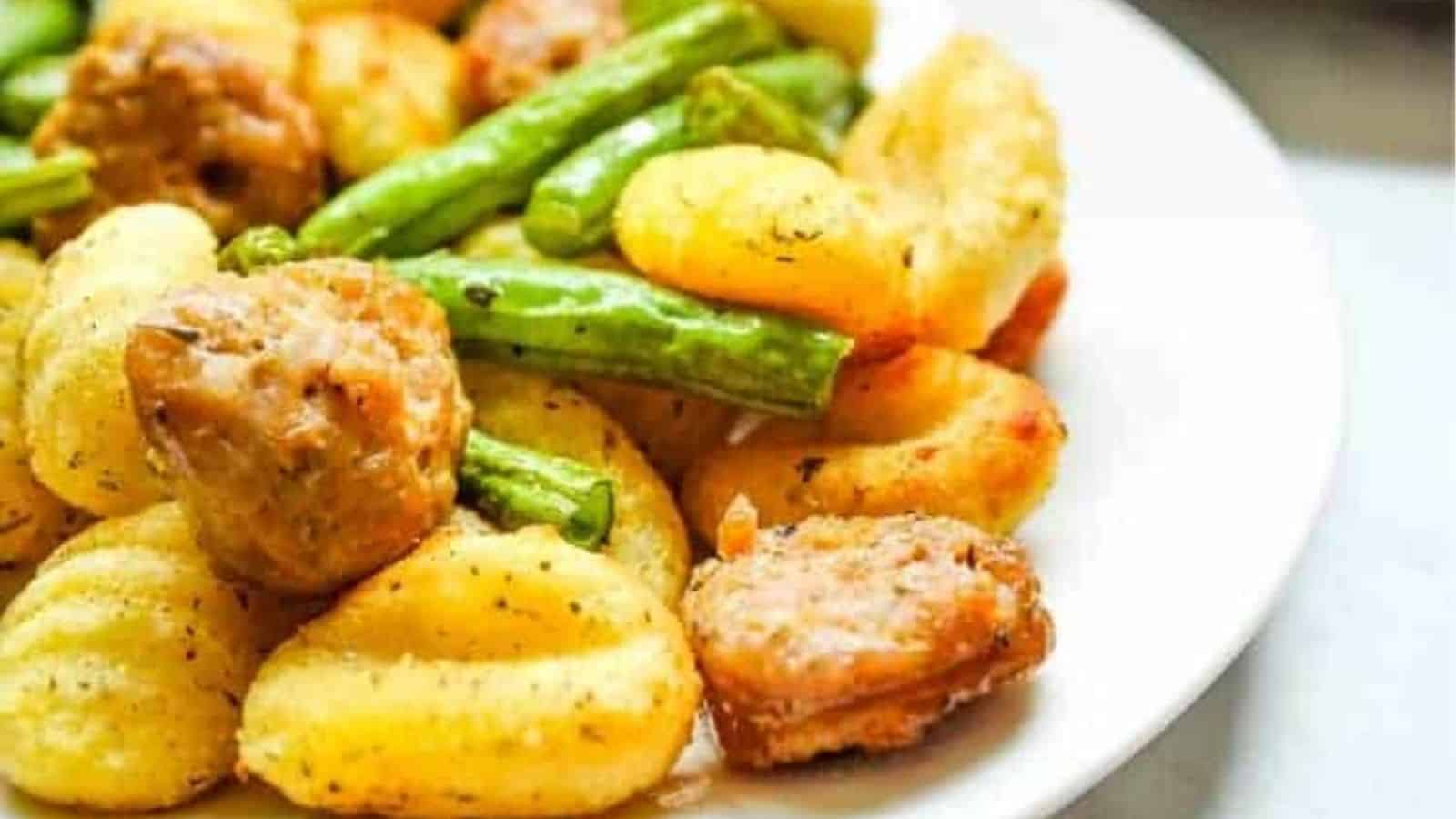 Close-up image of air fryer sausag gnocchi and green beans on a plate.