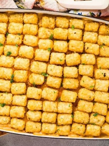 Top view of Chicken Tater Tot Casserole on a wooden board.