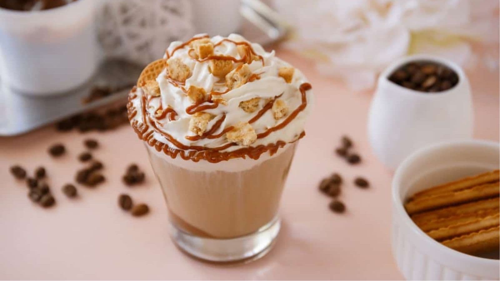 A cup of coffee with whipped cream and cinnamon sticks topped with Nigerian Jollof Rice.