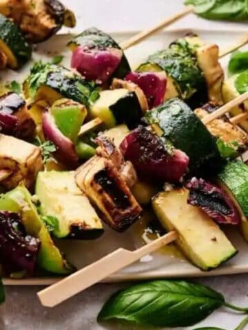 Close-up image of grilled veggie kabobs on a dish.