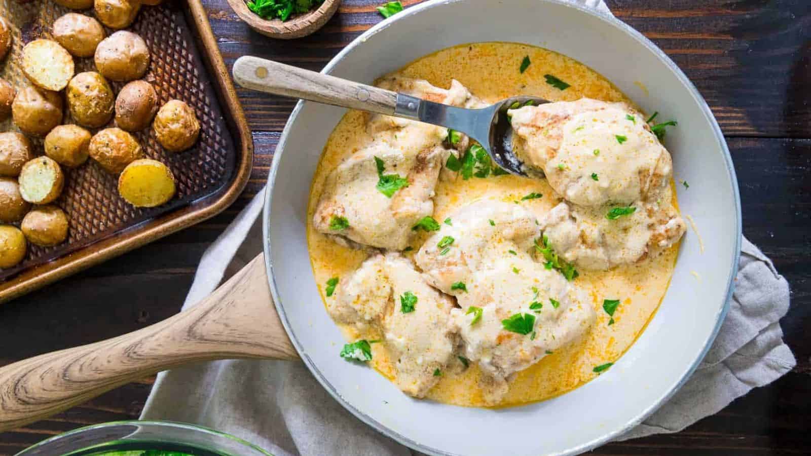 Cream cheese chicken in a white skillet.