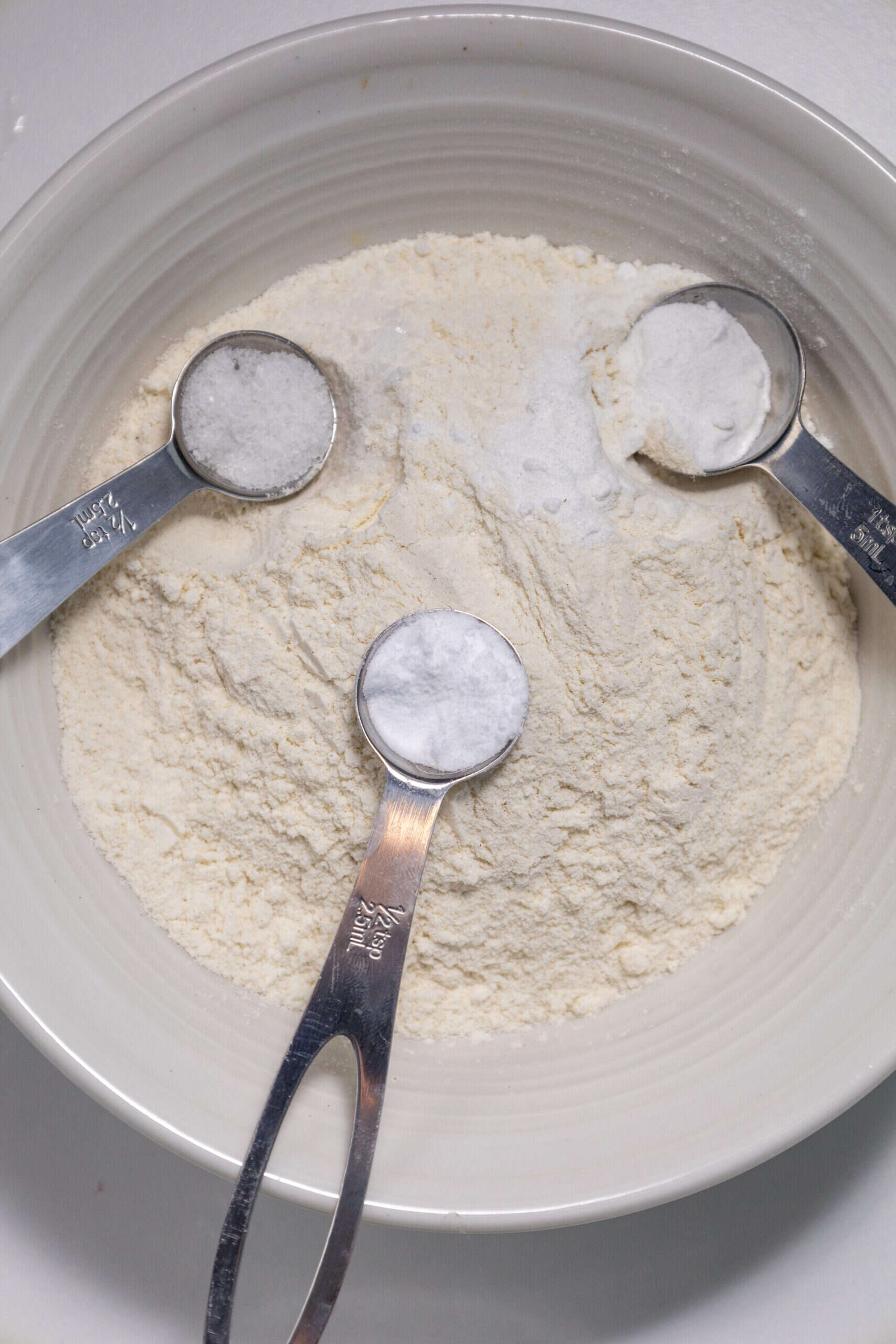 Close-up image of a mixing bowl filled with dry ingredients of strawberry delight pancakes.