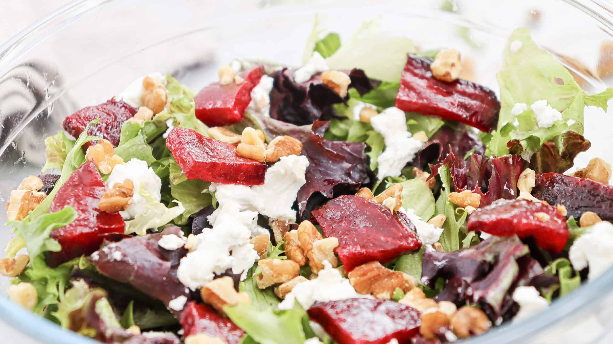 Close-up image of Grilled Beetroot and Goat Cheese Salad in a glass bowl.