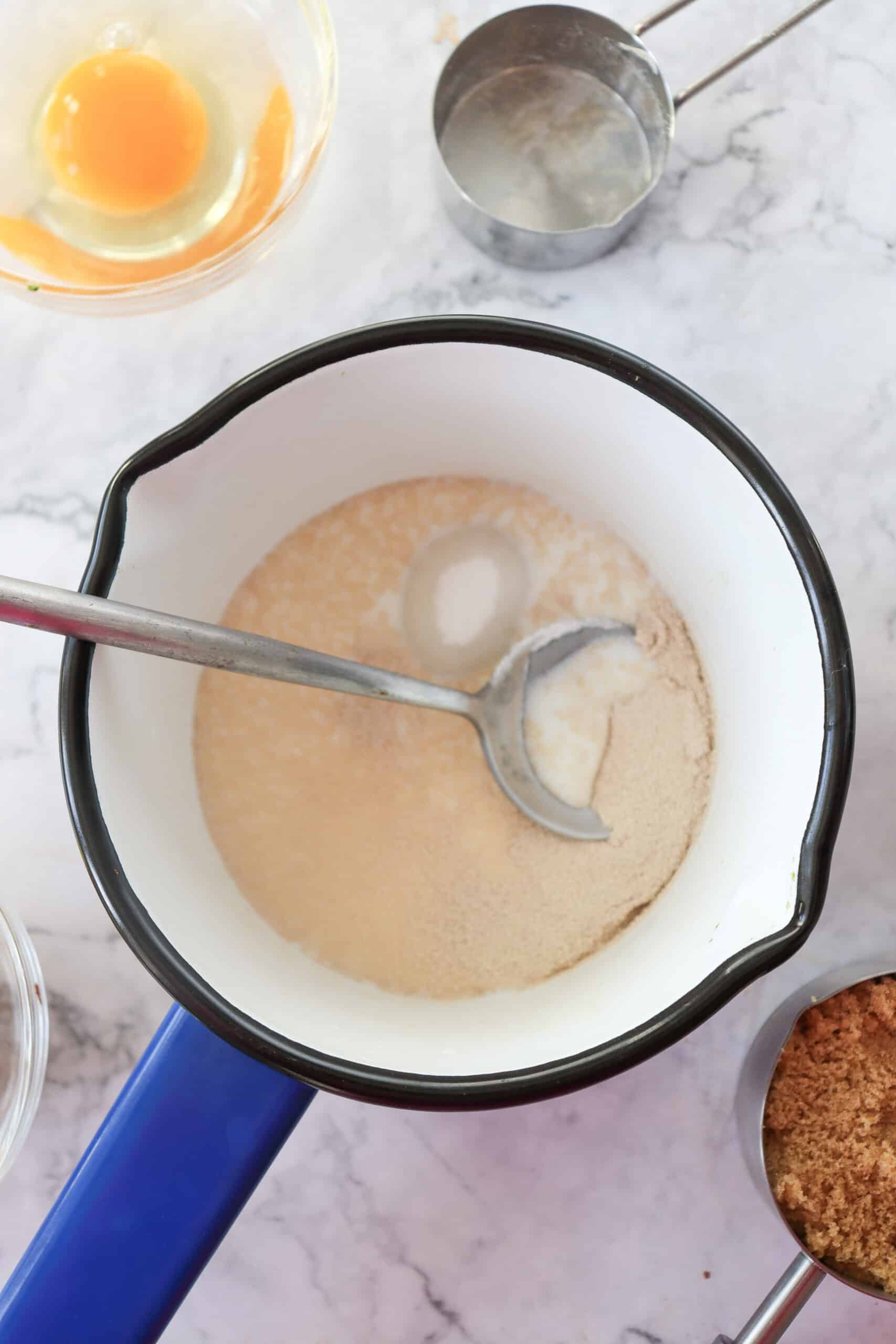 A small saucepan with milk, yeast, and sugar being gently heated.